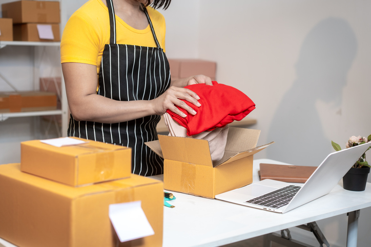 Woman packing orders in a box.